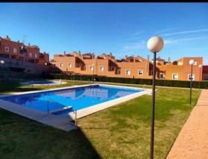 duży basen w podwórzu z domkami w obiekcie Casa adosada 3 habitaciones con piscina comunitaria w mieście Medina Sidonia