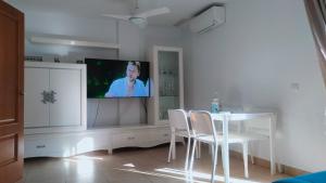 salon ze stołem, krzesłami i telewizorem w obiekcie Casa adosada 3 habitaciones con piscina comunitaria w mieście Medina Sidonia