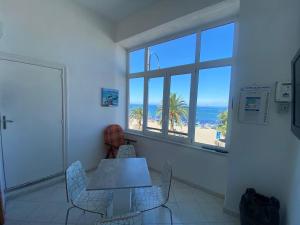 una mesa y sillas en una habitación con vistas al océano en Casa Rita in Piazza Marina en Isquia