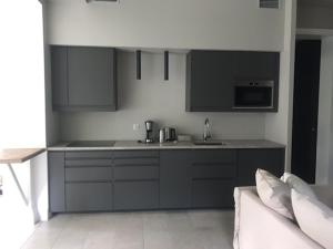 a kitchen with black and white cabinets and a couch at Villa Park Wisełka Spa & Wellness in Wisełka