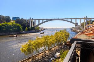 Blick auf einen Fluss mit einer Brücke im Hintergrund in der Unterkunft 108MM House in Porto