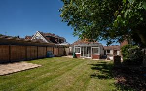 a backyard of a house with a yard withgrass at Botany Bay Holiday House - Family friendly, 50M from the beach in Kent