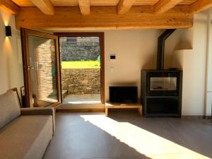ein Wohnzimmer mit einem Sofa und einem Kamin in der Unterkunft Chalet Del Sole in Monfol