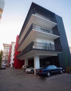 une voiture garée dans un parking en face d'un bâtiment dans l'établissement Luxury @ the Garden, à Accra