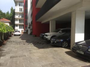 two cars parked in a garage next to a building at Luxury @ the Garden in Accra