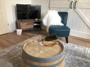 ein Wohnzimmer mit einem Fasstisch mit Weingläsern in der Unterkunft LIME&WINE - Stylishes Wohlfühl-Apartment am Rhein in Oestrich-Winkel