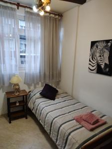 Habitación pequeña con cama y ventana en Palermo 3 Habitaciones privadas en Buenos Aires