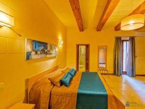 1 dormitorio con 1 cama grande en una habitación amarilla en The Almonds Luxury Villa, en San Lawrenz