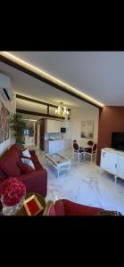 ein Wohnzimmer mit einem roten Sofa und einem Tisch in der Unterkunft El Comercio in Villarejo del Valle