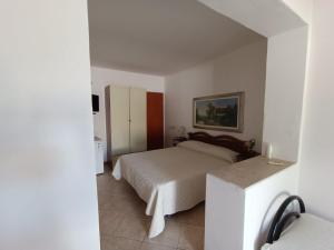 ein Schlafzimmer mit einem Bett und einem Kühlschrank. in der Unterkunft Acqua Cristallina in Arenella