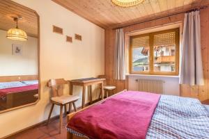 a bedroom with a bed and a table and chairs at Pension Sonia App 102 in Funes