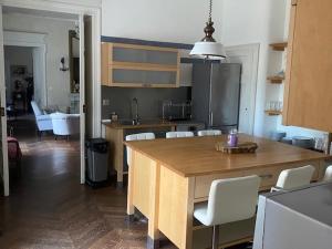 a kitchen with a large wooden table and white chairs at Domaine de ferrabouc in Mas-Saintes-Puelles