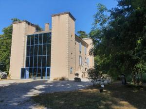 a large brick building with a large window at Domaine de ferrabouc in Mas-Saintes-Puelles