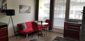 een woonkamer met een rode bank en een tafel bij Retro Apartment in Kaprun
