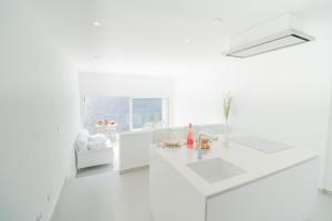 ein weißes Wohnzimmer mit einem weißen Sofa und einem Fenster in der Unterkunft Cloud on the sea in Callao Salvaje