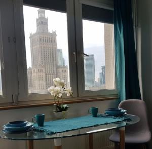 - une table dans une fenêtre avec vue sur la ville dans l'établissement DELUXE WIDOK 24 APARTMENT, à Varsovie