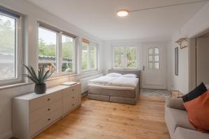a bedroom with a bed and a couch and windows at Villa Hoheneck in Wildemann