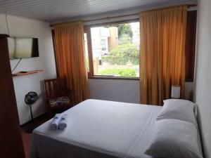 a bedroom with a white bed and a window at Tucuma Casa Hotel in Leticia