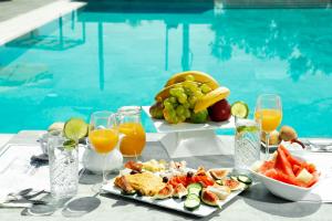 a table with a tray of food and drinks next to a pool at 4-you Residence in Ayios Nikolaos Sithonia