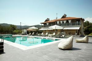 a swimming pool with benches and umbrellas next to a building at 4-you Residence in Ayios Nikolaos Sithonia