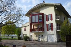 a house with red shuttered windows and a driveway at Gerwies-Hof in Bronzolo