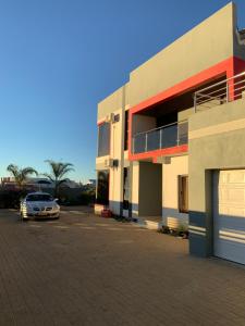 a car parked in a parking lot next to a building at Almina villa in Windhoek