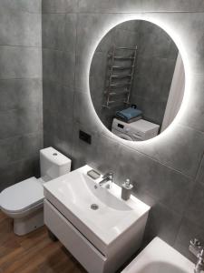 y baño con lavabo blanco y espejo. en Люкс Апартаменты Gray Pearl на Подолье, en Vínnytsia