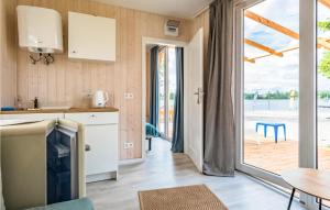 a kitchen with a table and a door to a patio at Gorgeous Home In Rydzewo With House Sea View in Rydzewo