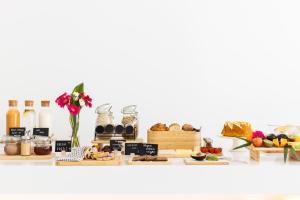 a shelf with a variety of bread and other food items at Vila Maria Hotel - Adults Only in Albufeira