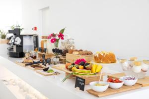 a breakfast buffet with bread and other foods on a counter at Vila Maria Hotel - Adults Only in Albufeira