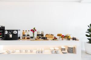 a white shelf with plates and cups and dishes at Vila Maria Hotel - Adults Only in Albufeira