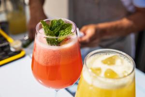a drink in a glass with a mint leaf on top at Vila Maria Hotel - Adults Only in Albufeira