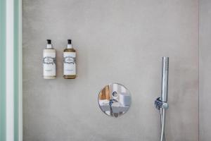 two bottles of wine and a mirror on a wall at Vila Maria Hotel - Adults Only in Albufeira