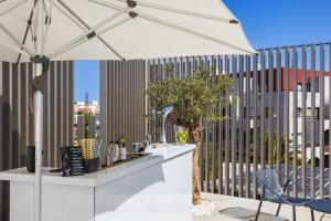 a white umbrella sitting on top of a patio at Vila Maria Hotel - Adults Only in Albufeira