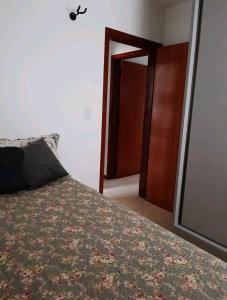 um quarto com uma cama e uma porta aberta em Apê aconchegante e quentinho em São Joaquim em São Joaquim