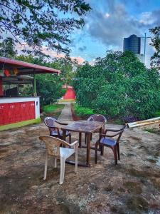 a table and chairs sitting around a table and chairs at Farmhouse with Pool - Kalavady Farmstay in Baindūru