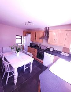 eine Küche mit einem weißen Tisch und einem weißen Kühlschrank in der Unterkunft Glan-Yr-afon cottage two bedrooms in Sennybridge