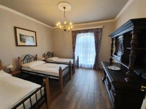 a bedroom with two beds and a chandelier at Lesní Hotel Peršlák in Nová Bystřice