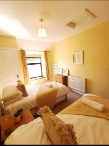 1 Schlafzimmer mit 3 Betten und einem Fenster in der Unterkunft Glan-Yr-afon cottage two bedrooms in Sennybridge