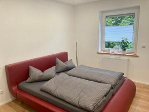 a red couch in a room with a window at Schiller Apartment in Münchberg