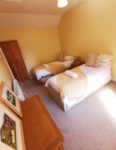 1 Schlafzimmer mit 2 Betten und einem Holztisch in der Unterkunft Glan-Yr-afon cottage two bedrooms in Sennybridge