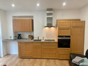 a kitchen with wooden cabinets and a sink and a stove at Schiller Apartment in Münchberg