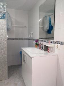 een witte badkamer met een wastafel en een spiegel bij La magia del sur 2 in Cádiz