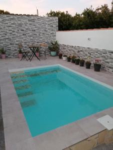 een zwembad in een patio met een tafel en stoelen bij La magia del sur 2 in Cádiz