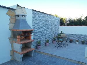 een patio met een bakstenen open haard en een tafel bij La magia del sur 2 in Cádiz