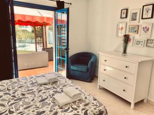 sypialnia z łóżkiem, krzesłem i komodą w obiekcie Villa Jardín w mieście Playa Blanca