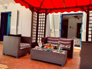 プラヤ・ブランカにあるVilla Jardínのパティオ(テーブル、椅子、赤い傘付)