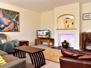 a living room with a couch and a tv at Pass the Keys Spacious 4 Bedroom home with Parking Garden in Barry