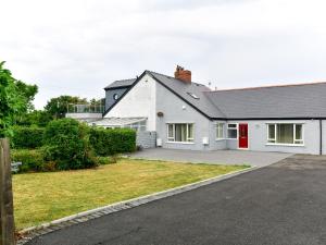 a white house with a red door and a driveway at Pass the Keys Spacious 4 Bedroom home with Parking Garden in Barry
