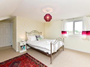 a bedroom with a bed and a large window at Pass the Keys Spacious 4 Bedroom home with Parking Garden in Barry